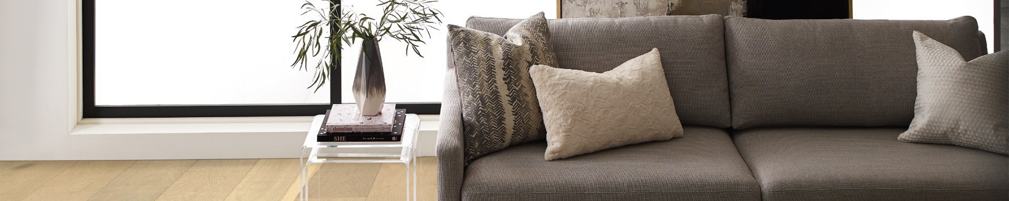 grey couch with side table in front of large window