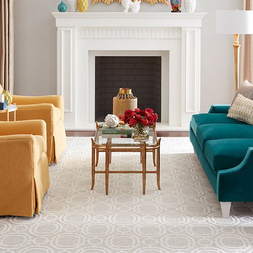 green sofa and two yellow armchairs in front of a fireplace on a white carpet floor from Potomac Tile and Carpet in Frederick, MD